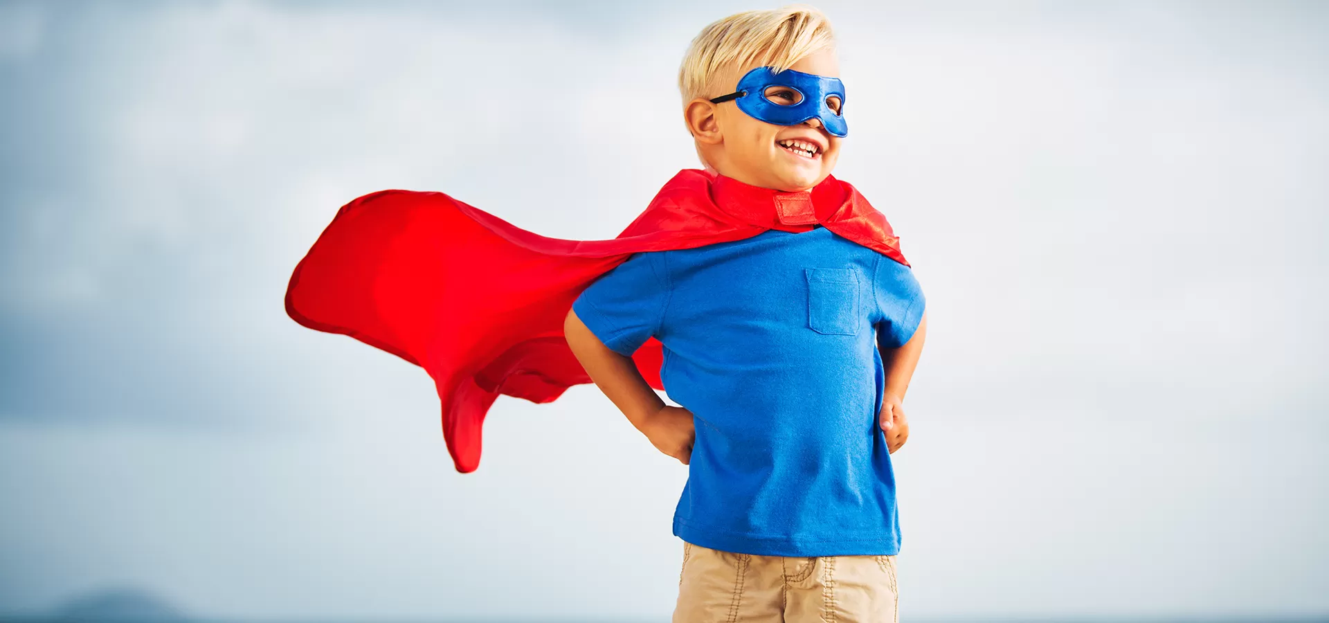 young child with superhero cape