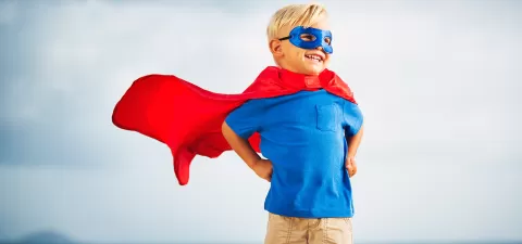 young child with superhero cape